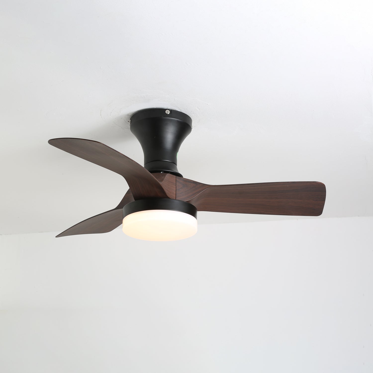 Vista dettagliata delle pale con grana legno e del diffusore in acrilico del ventilatore da soffitto Nora con luce.