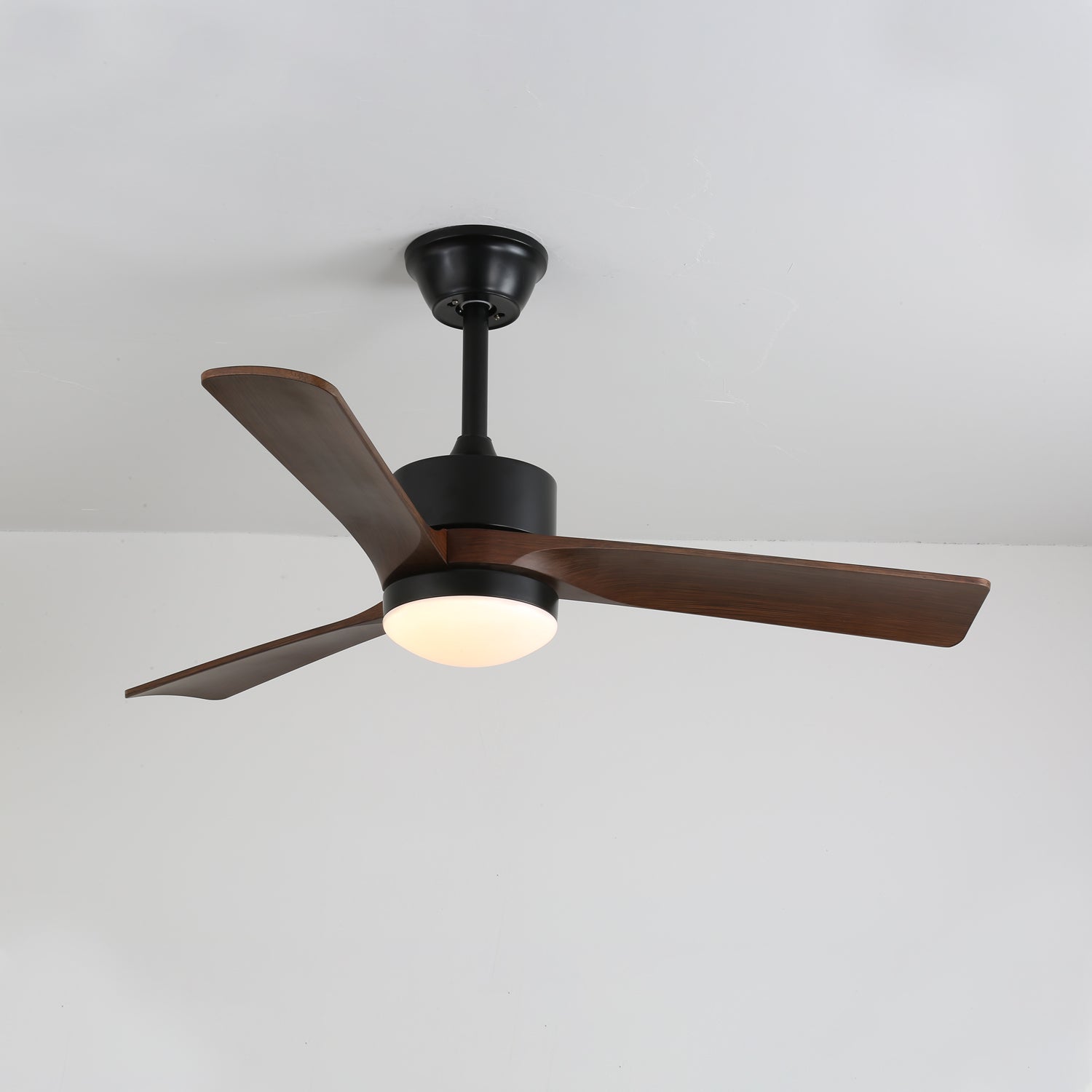 Vista ravvicinata delle pale in legno di noce del ventilatore da soffitto Evraeis.
