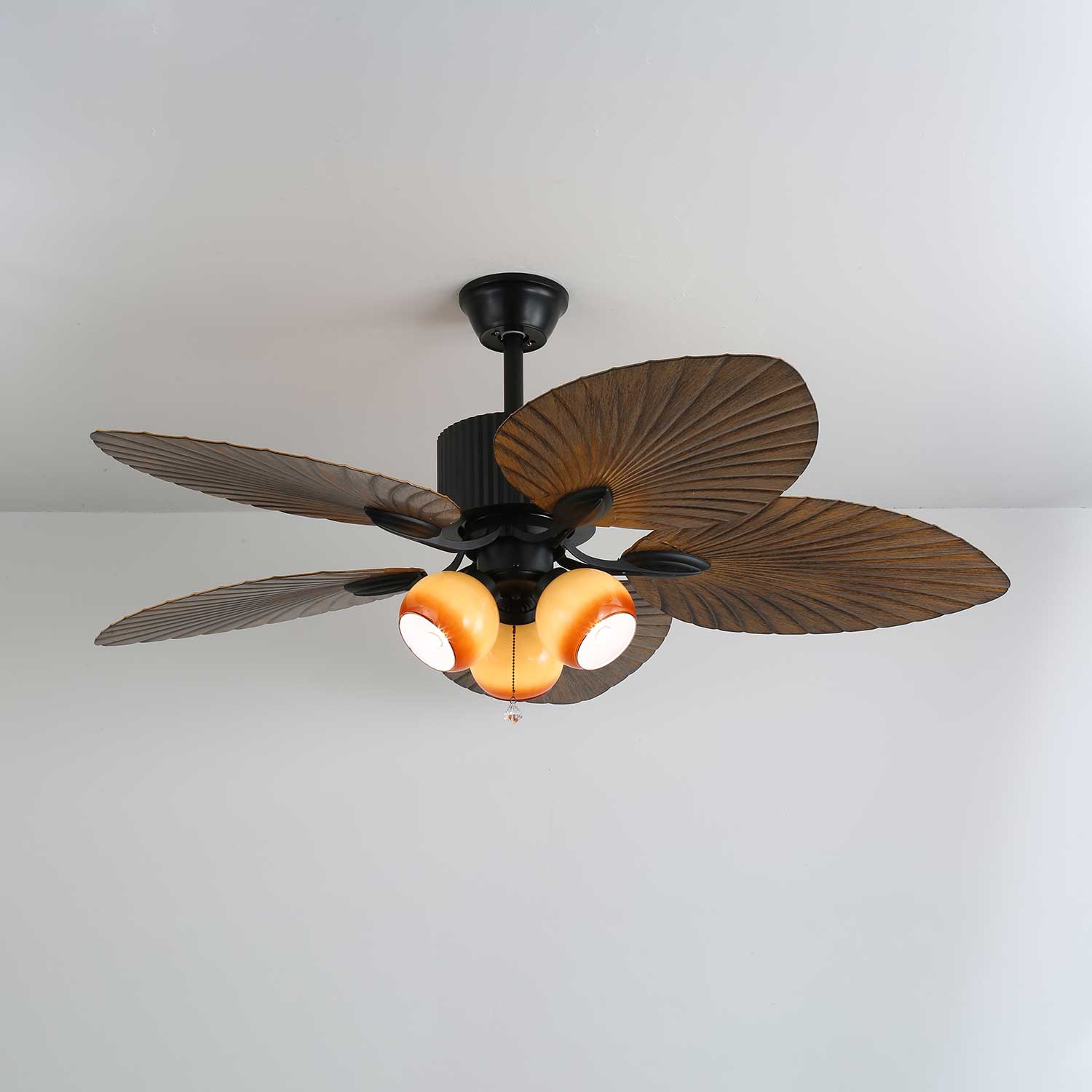 Primo piano della finitura in legno di noce e delle pale in ABS del ventilatore da soffitto.